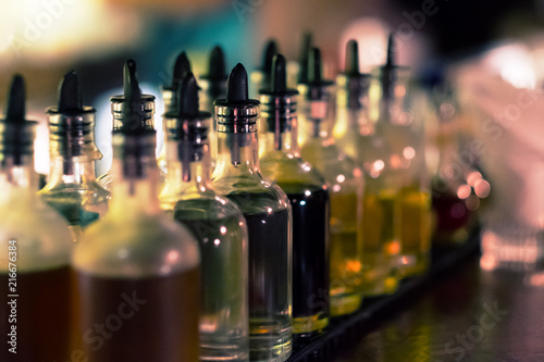 Bottles with syrups for mixing cocktails on bar counter. Alcohol drinks ingredients. Professional cocktail liquors. Horizontal image with selective focus. 