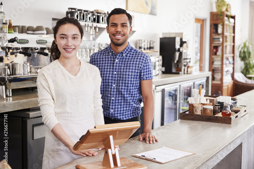 Mixed race couple behind the counter at their coffee shop