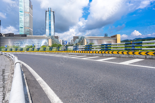 empty asphalt road with city skyline