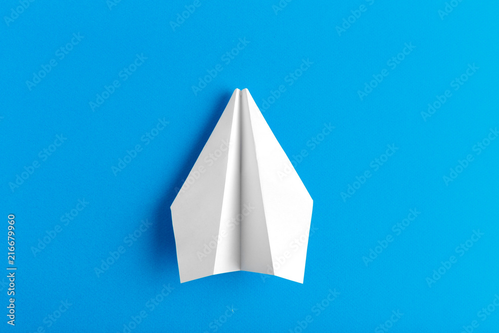 Flat lay of a paper plane on pastel blue color background Flat lay of a paper plane on pastel blue color background