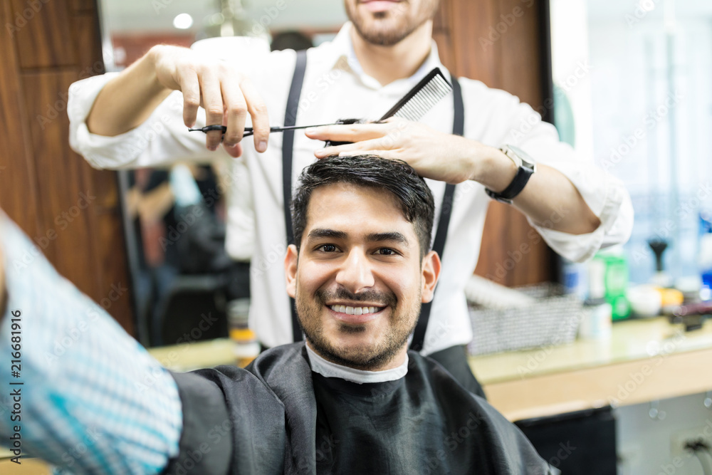 Customer Taking Selfie While Stylist Cutting His Hair With Scissors Customer Taking Selfie While Stylist Cutting His Hair With Scissors