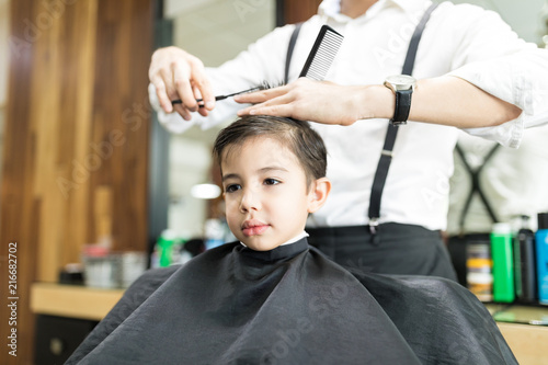 Boy Sitting At Hairdresser Salon For Haircut