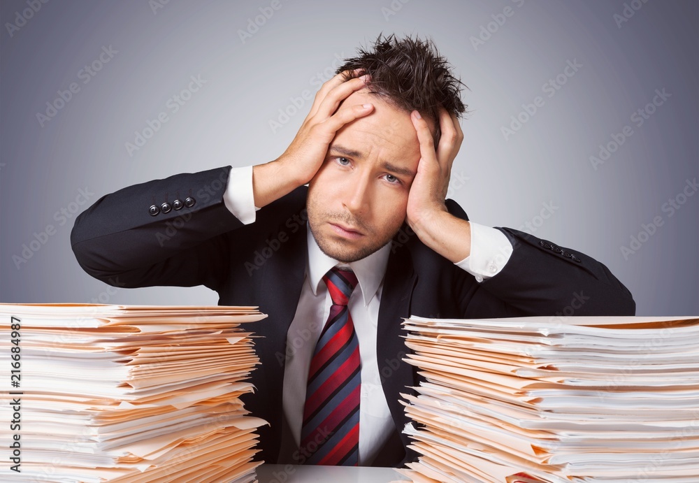Young businessman hid behind with stack papers Young businessman hid behind with stack papers