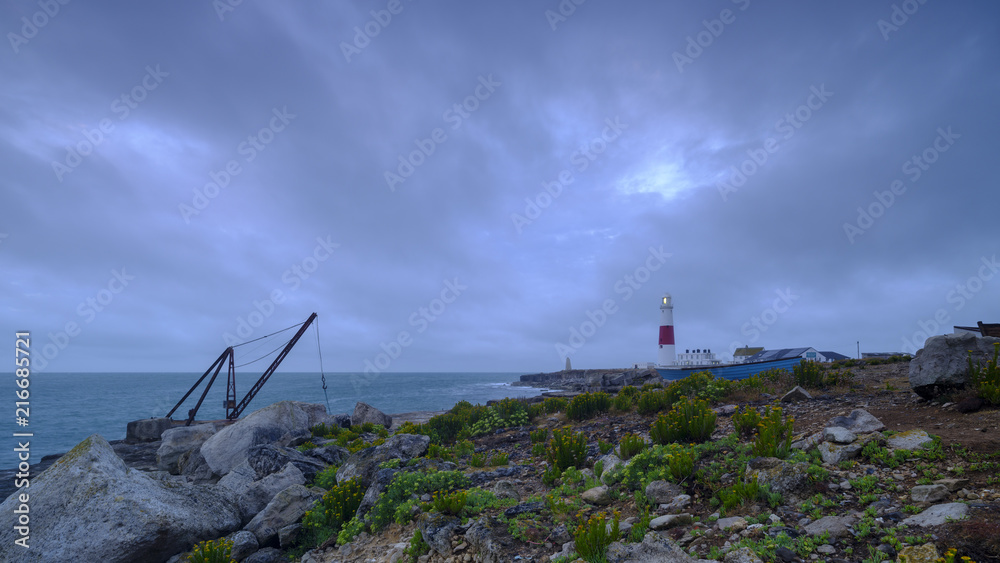 Summer sunrise with stormy clouds and slow shutter speed at Portland Bill Light, Dorset, UK Summer sunrise with stormy clouds and slow shutter speed at Portland Bill Light, Dorset, UK