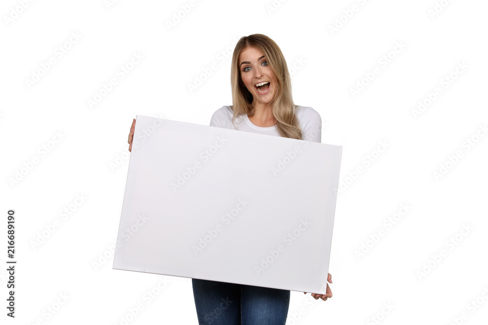 Hübsche blonde Frau schaut begeistert und hält eine leere Leinwand in ihren Händen Hübsche blonde Frau schaut begeistert und hält eine leere Leinwand in ihren Händen
