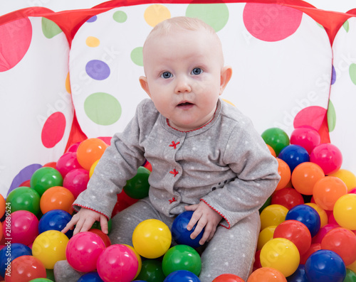 Baby playing with balls in the playground 