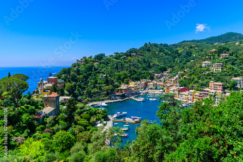 Portofino, Italy - colorful houses and yacht in little bay harbor. Liguria, Genoa province, Italy. Italian fishing village with beautiful sea coast landscape in summer season.