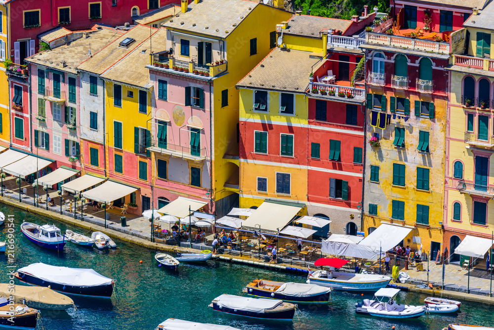 Portofino, Italy - colorful houses and yacht in little bay harbor. Liguria, Genoa province, Italy. Italian fishing village with beautiful sea coast landscape in summer season.