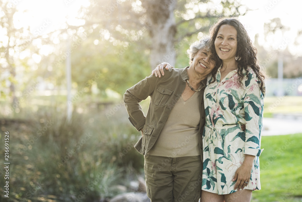 Portrait of happy mother and daughter standing at park