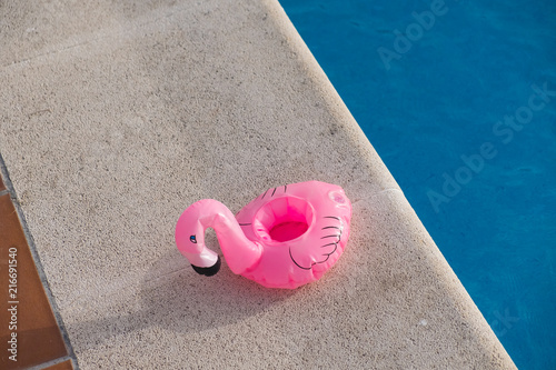 Flamenco rosa hinchable de plástico junto a una piscina photo