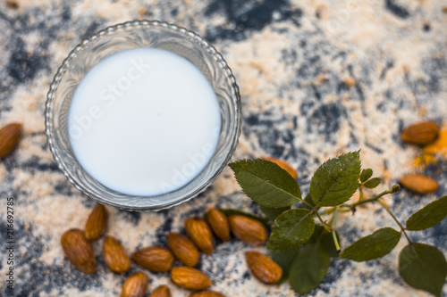 Close up of oats face pack or Avena sativa facial mask i.e  crushed or powdered almonds or badam,milk and grounded oats on wooden surface.This face pack is widely used in spa for de-tanning. photo