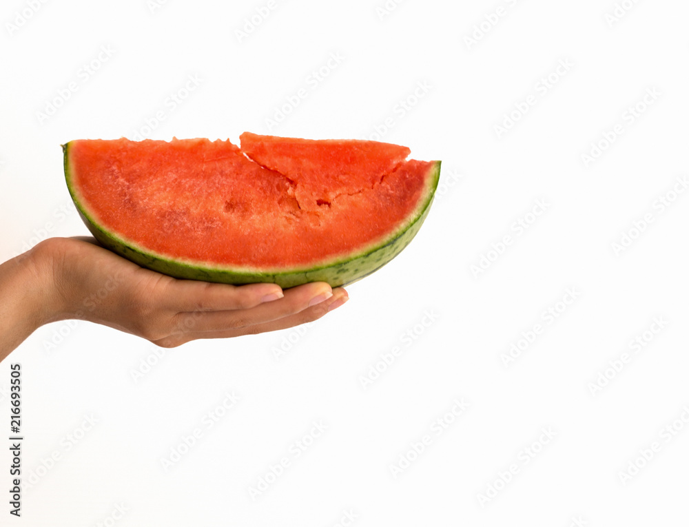 Hand holding slice of watermelon with a blurred background Hand holding slice of watermelon with a blurred background