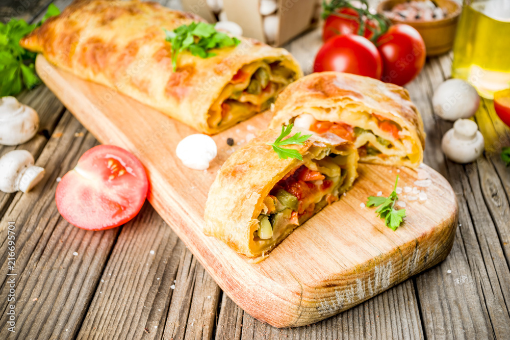 Vegetable savory strudel, homemade autumn baking, with tomatoes, bell pepper, mushrooms, wooden background copy space Vegetable savory strudel, homemade autumn baking, with tomatoes, bell pepper, mushrooms, wooden background copy space
