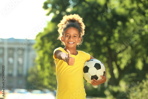 Cute African American girl with soccer ball in park