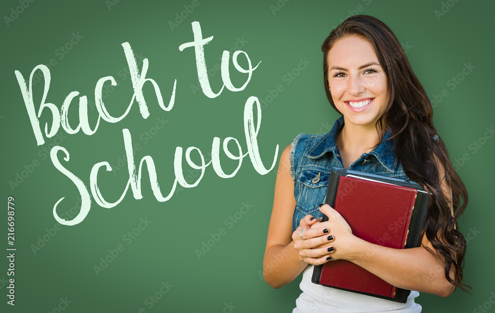 Back To School Written On Chalk Board Behind Mixed Race Young Girl Student Holding Books Back To School Written On Chalk Board Behind Mixed Race Young Girl Student Holding Books
