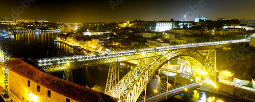 Dom Luís I Bridge in the night in Porto, Portugal, Europe. Golden bridge, ligtning to the river, reflection. Night city Porto.