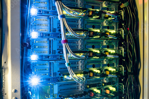 Computer technology works in a dark server room of the data center. Bright indication on network interfaces. Equipment for mining of crypto currency