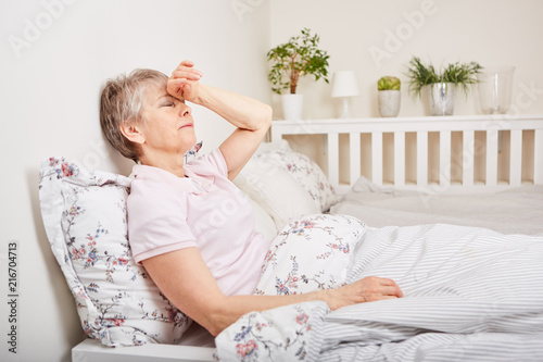 Alte Frau liegt krank im Bett photo