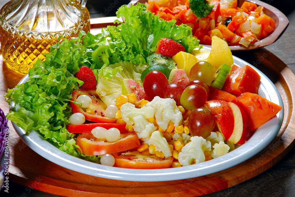 Plate of salad with vegetables and fruits, lettuce, tomato