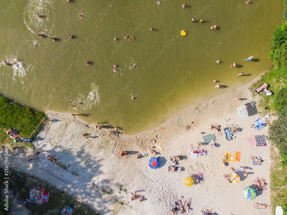LVIV, UKRAINE - 9 JUNE, 2018: people sunbathing, swimming, resting at sand beach near lake. aerial view