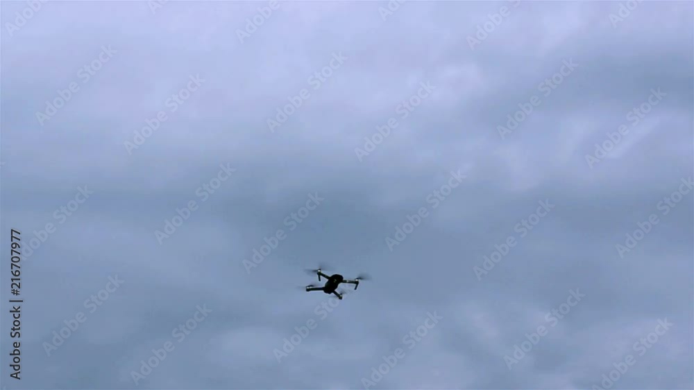Little drone or quadrocopter flies in the blue cloudy sky. Outdoors.