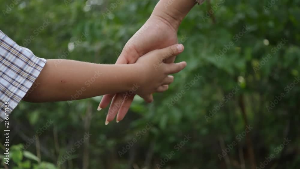 Close up hand of the Mother holding the son hand in slow motion scene Close up hand of the Mother holding the son hand in slow motion scene