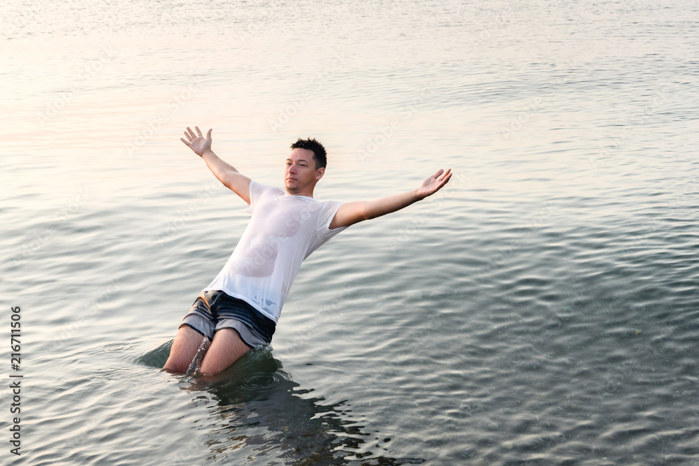 Young man falling in the water with his back Young man falling in the water with his back