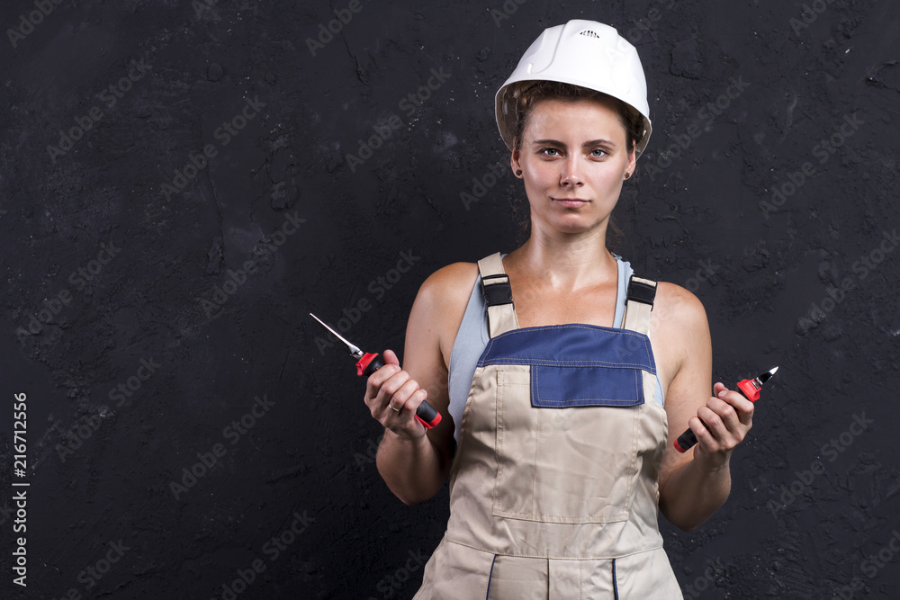 Portrait of electrician woman in uniform and white helmet holds in hand  wire-cutters and nippers. Female worker in workwear with electric tools in  her hands Stock Photo | Adobe Stock