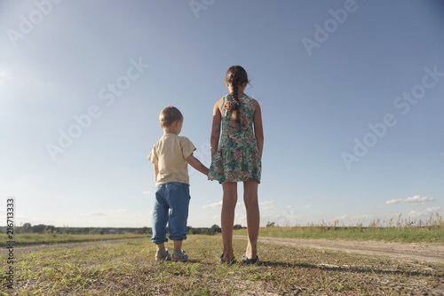 small boy and girl standing on a rural road