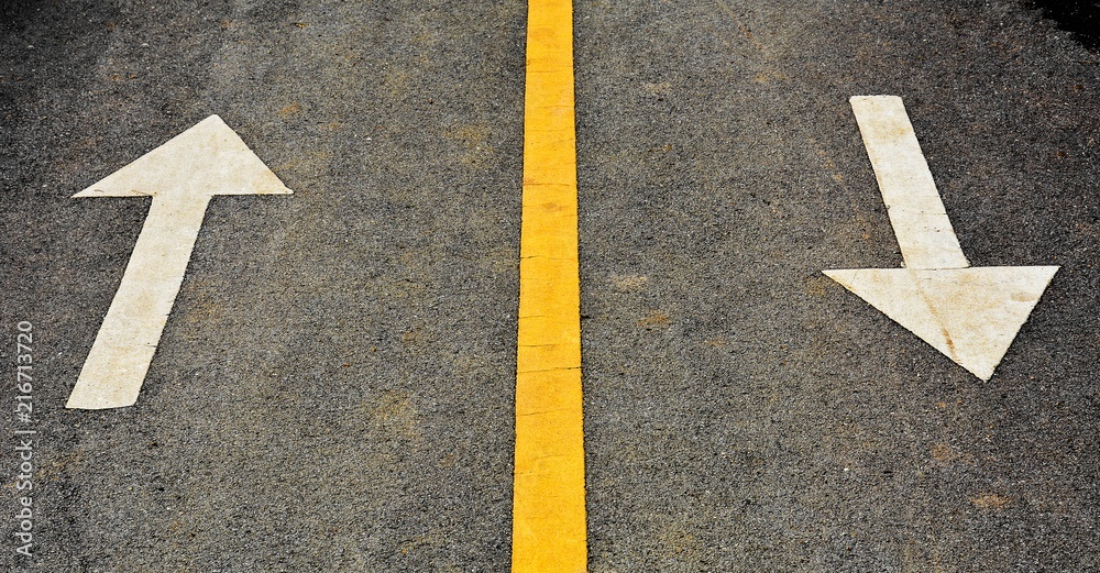 white arrow painted on asphalt road