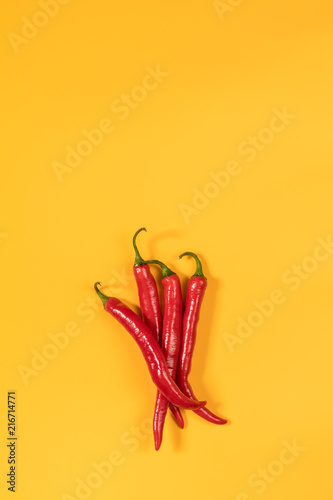 Fototapeta Czerwona papryczka chili na żółtej powierzchni. Piękne minimalistyczne tło sztuki żywności