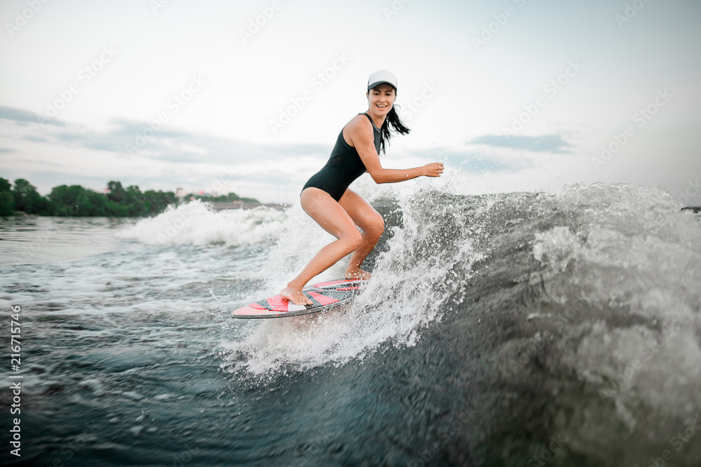 Active woman riding on the wakesurf on the bending knees