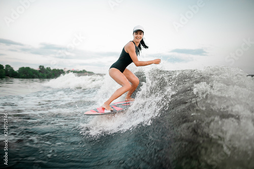 Active woman riding on the wakesurf on the bending knees