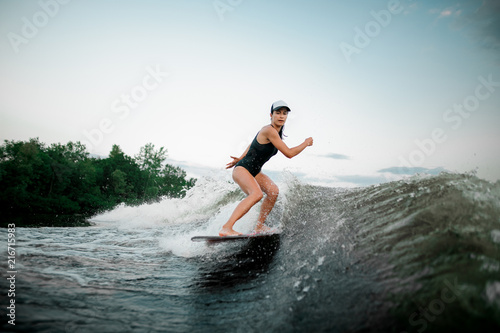 Attractive girl riding on the wakesurf on the bending knees