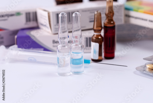 Ampoules for injections against the background of packs with medicines. Medical concept