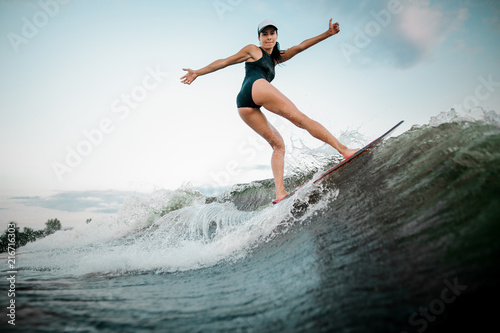 Rear view sexy woman jumping on the orange wakesurf