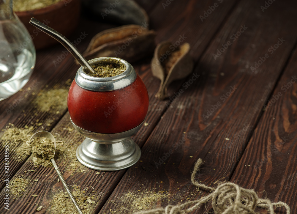 Mate yerba tea in calabash on wooden table. Traditional argentinian beverage