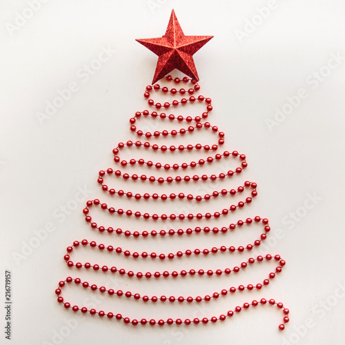 Creative idea in minimalistic style for Christmas or New Year themes. Christmas fir-tree from beads and a star on top. Festive concept
