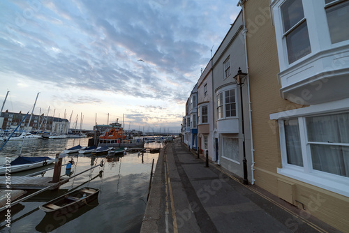 Sunrise at Weymouth Harbour on a warm summer's morning. Boats and small fishing vessels are moored up. © Peter Sterling