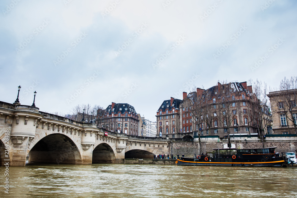 Boat at the Seine river next to the Pont Neuf in a cold winter day in Paris