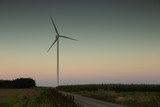 Wind mill on a field during warm sunrise light. Summer day. Green eco friendly energy source. Copy space