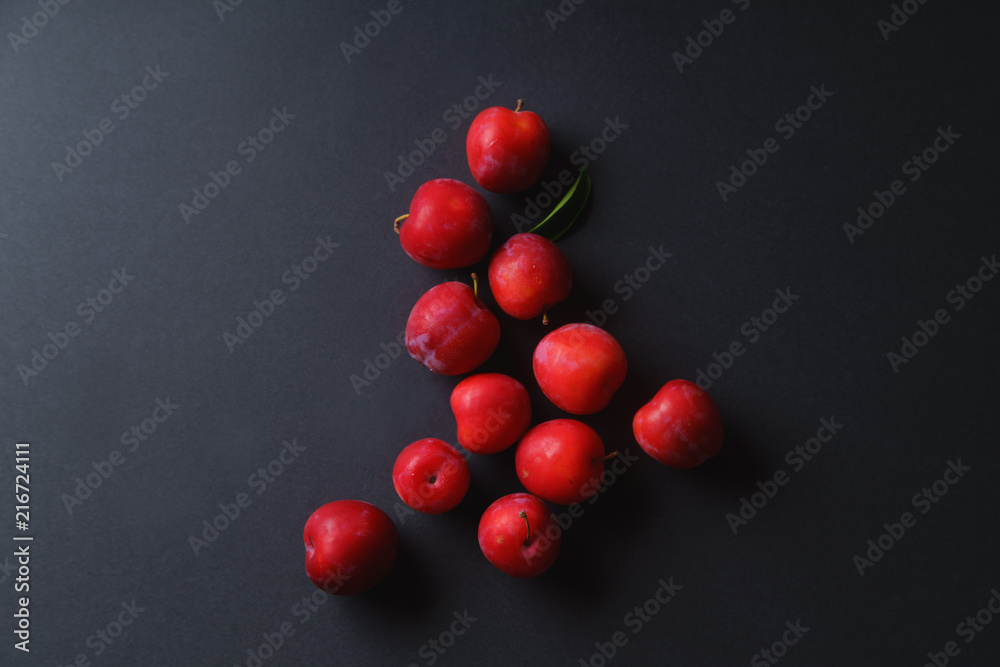 Red sweet cherry plums on dark background. Overhead view