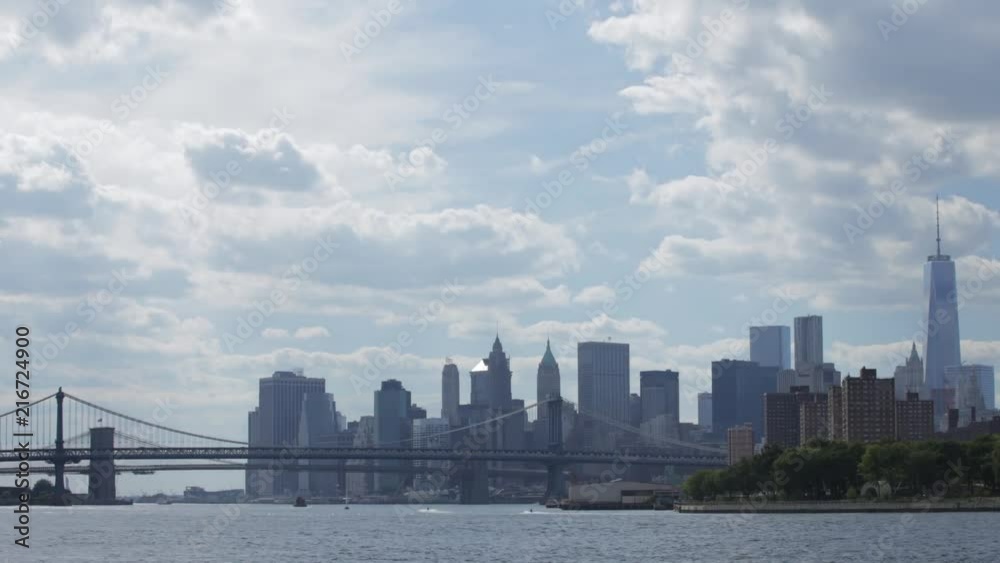 Timelapse of downtown new york city skyline, brooklyn bridge and manhattan bridge along the east river on a sunny summer day. Timelapse of downtown new york city skyline, brooklyn bridge and manhattan bridge along the east river on a sunny summer day.