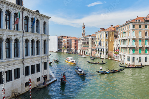 Bridge Rialto on Grand canal.  Famous landmark panoramic view Venice Italy with blue sky white cloud and many gondola boat water.