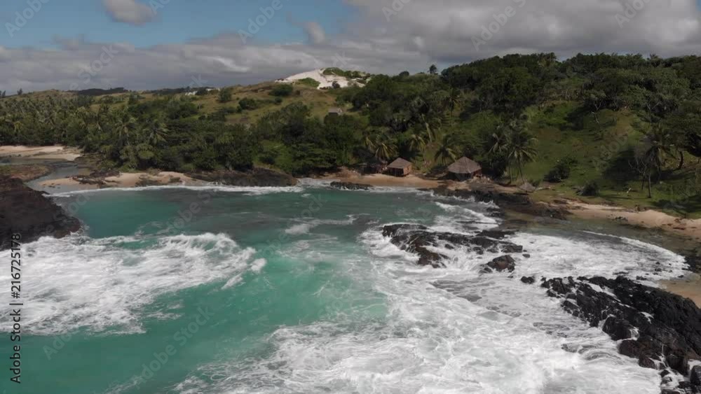 Aerial view of a tropical cove with waves crashing on rocks Aerial view of a tropical cove with waves crashing on rocks