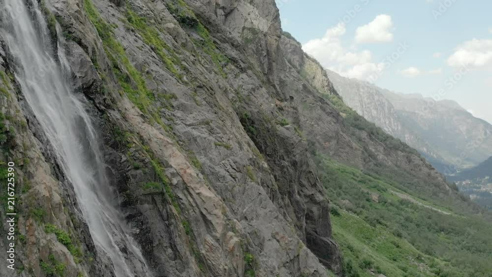 Tracking and top shot Air shot from a stream of water splashing waterfall on a rock wall in the Caucasus Mountains. Around the jet of the waterfall Tracking and top shot Air shot from a stream of water splashing waterfall on a rock wall in the Caucasus Mountains. Around the jet of the waterfall