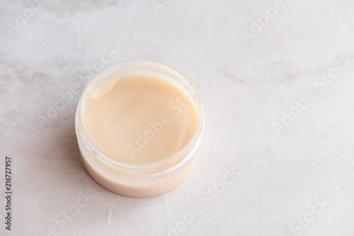 Spa cosmetics  open jar with skin care product on white marble background from above. Beauty blogging concept. Copyspace