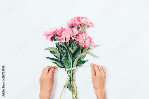 Fototapeta Naklejka Na Ścianę i Meble -  Female's hands decorate a bouquet of pink peony flowers