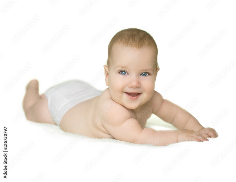 Adorable baby boy with blue eyes laughing and lying on stomach on bedding wearing diaper isolated on white background Adorable baby boy with blue eyes laughing and lying on stomach on bedding wearing diaper isolated on white background