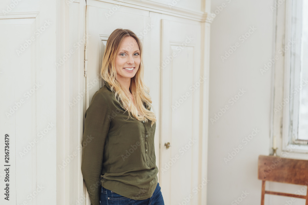 Woman standing leaning against an apartment door Woman standing leaning against an apartment door